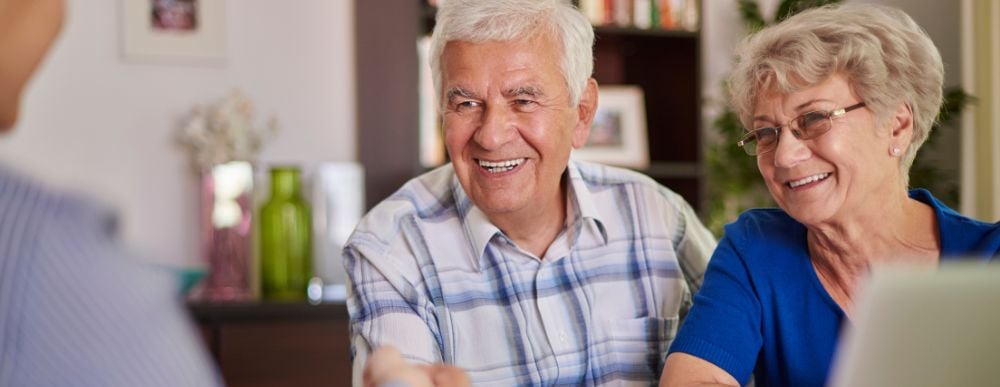 Pareja de adultos mayores sonriendo tras contratar uno de los créditos FOVISSSTE para pensionados