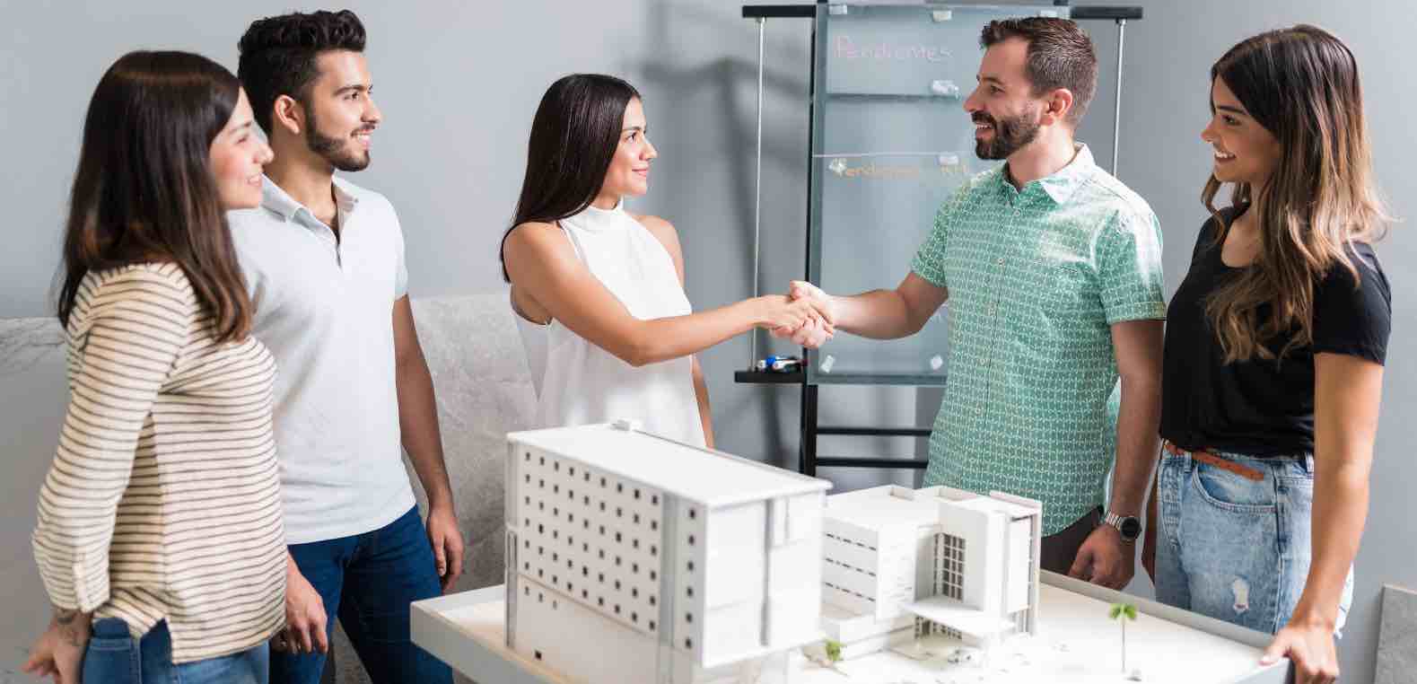 Mujer dando la mano a un hombre en señal de acuerdo por comprar una casa usando los fondos de su AFORE