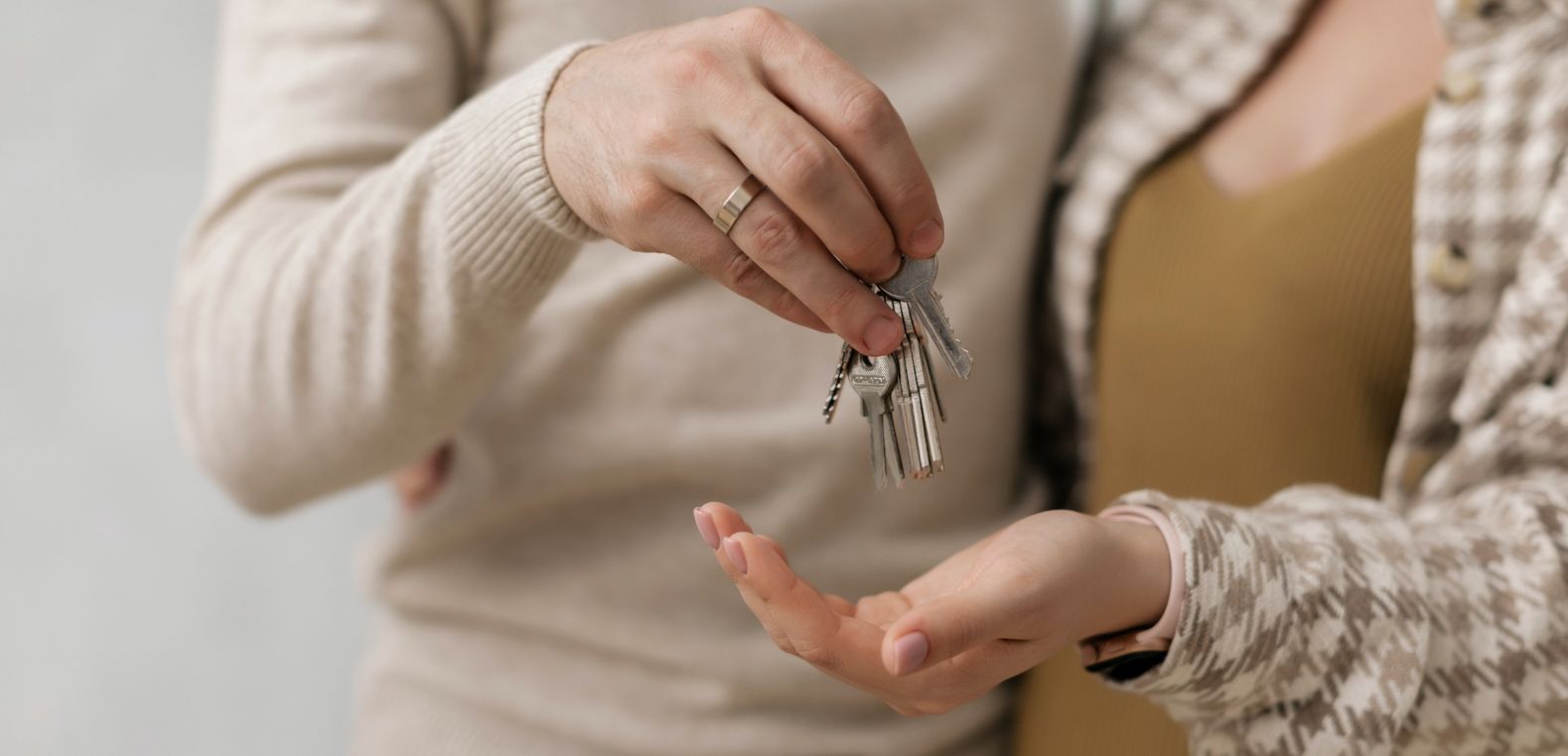 Hombre entregando unas llaves a su pareja luego de calcular sus puntos Infonavit y comprar una casa