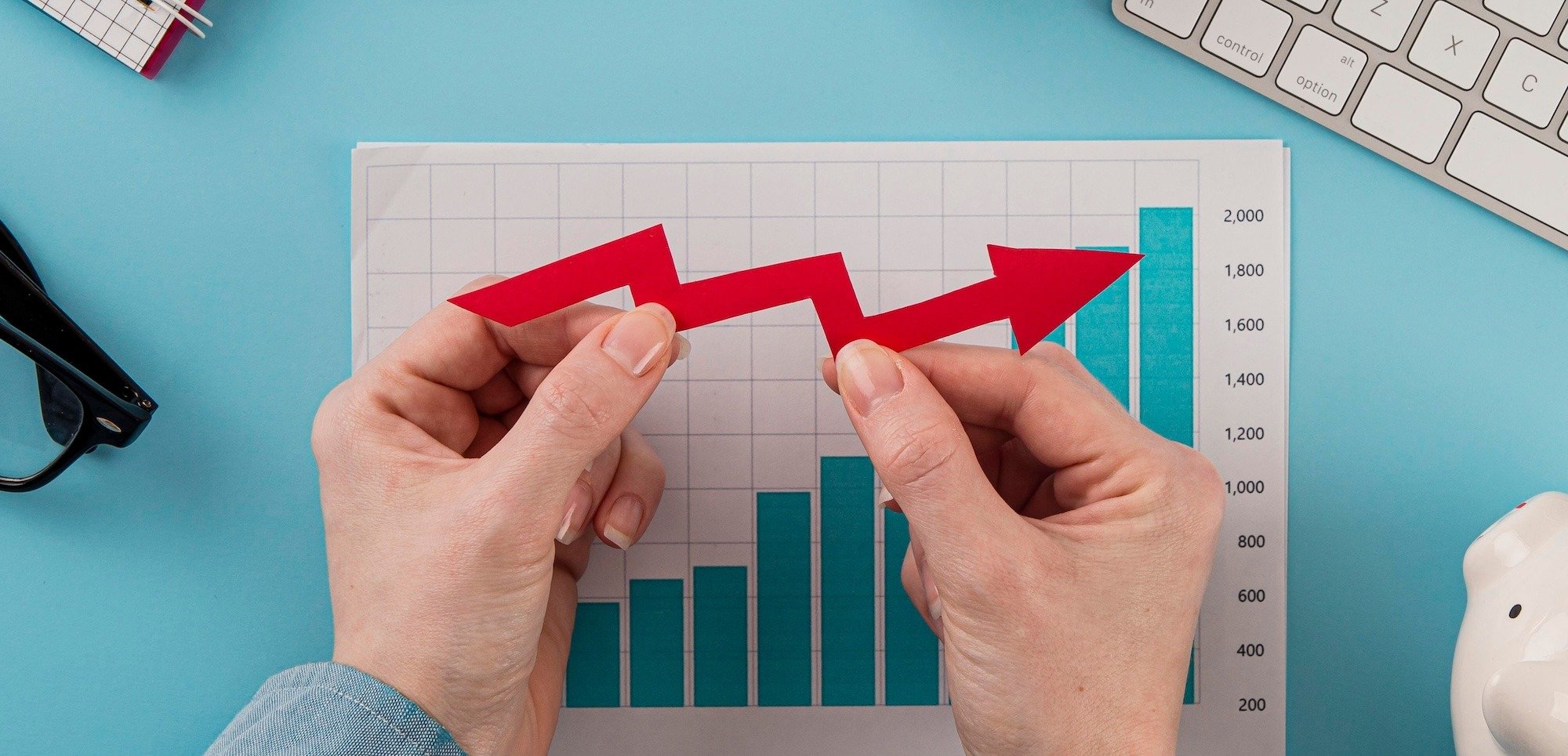 Tabla de crecimiento y manos sosteniendo una flecha indicando el aumento de los puntos Infonavit