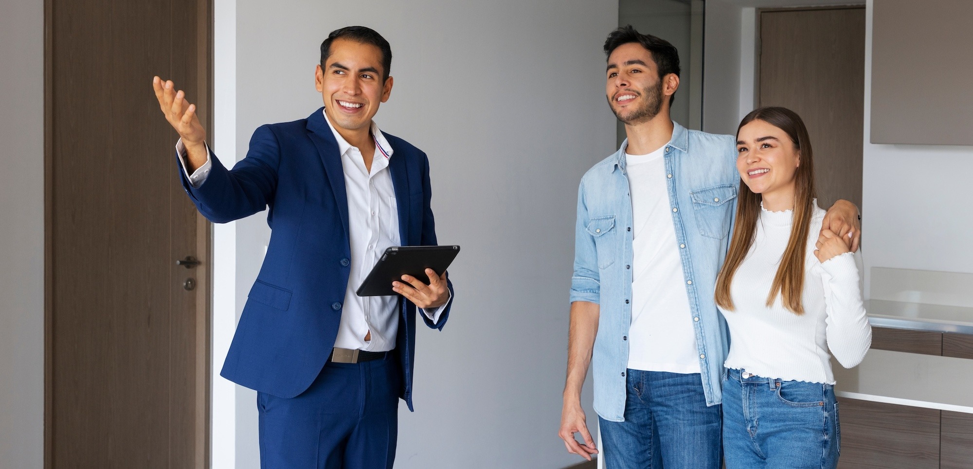 Pareja hablando con un desarrollador inmobiliario que les muestra una nueva casa